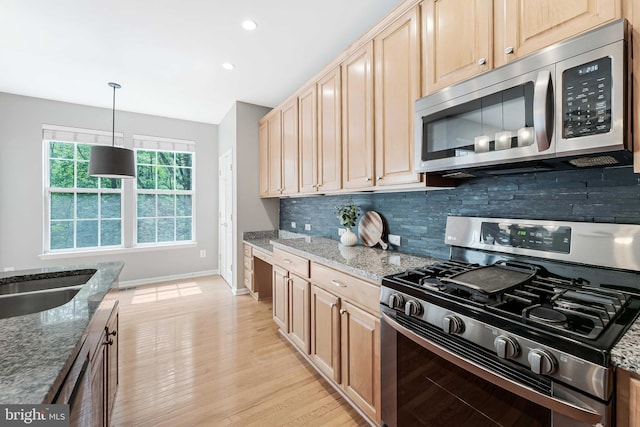 43103 Forest Edge Sq, Broadlands, VA 20148 - kitchen with stainless steel appliances, light brown cabinetry, decorative backsplash, stone counters, and light wood finished floors
