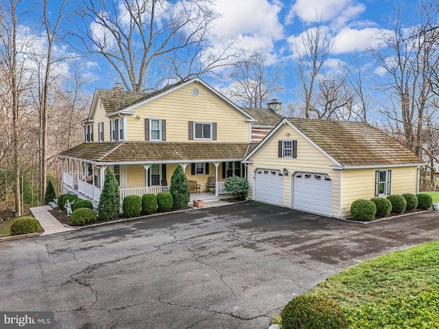 9020 Old Dominion Dr, Mclean, VA 22102 - view of front of property featuring a chimney, a porch, driveway, and a garage
