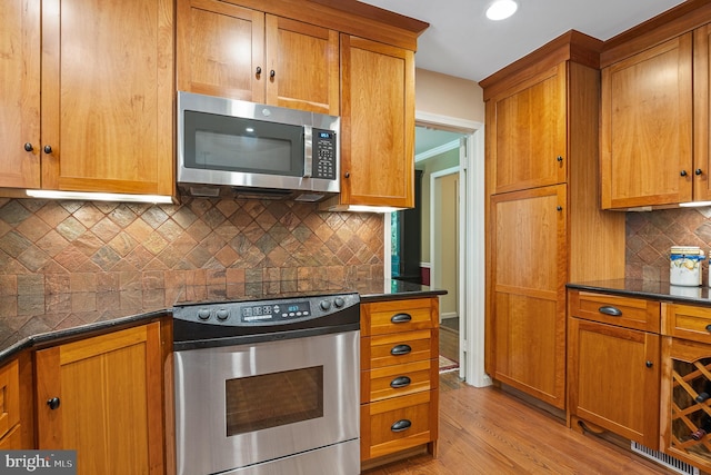 9020 Old Dominion Dr, Mclean, VA 22102 - kitchen with appliances with stainless steel finishes, dark countertops, light wood finished floors, brown cabinets, and recessed lighting