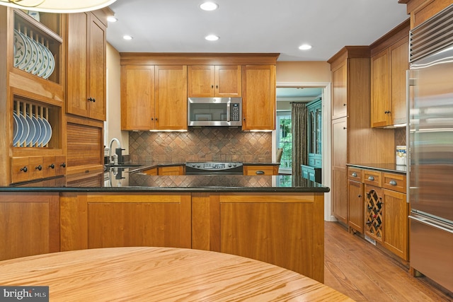9020 Old Dominion Dr, Mclean, VA 22102 - kitchen with stainless steel appliances, a sink, brown cabinetry, decorative backsplash, and wood finished floors