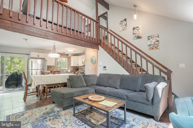7572 Eagle Rock Dr, Tobyhanna, PA 18466 - living room featuring healthy amount of natural light, wood finished floors, stairway, and high vaulted ceiling