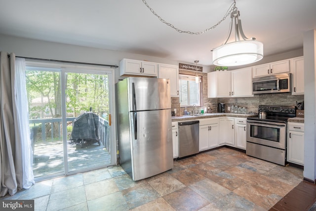 7572 Eagle Rock Dr, Tobyhanna, PA 18466 - kitchen featuring stainless steel appliances, decorative backsplash, white cabinetry, and stone tile floors