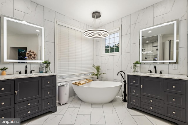 13128 Kahns Rd, Manassas, VA 20112 - full bathroom featuring tile walls, marble look tile flooring, two vanities, a chandelier, and a freestanding bath