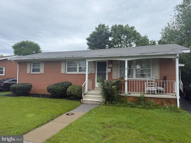 211 Wood Ave, Winchester, VA 22601 - view of front of property featuring brick siding, a front yard, and a porch
