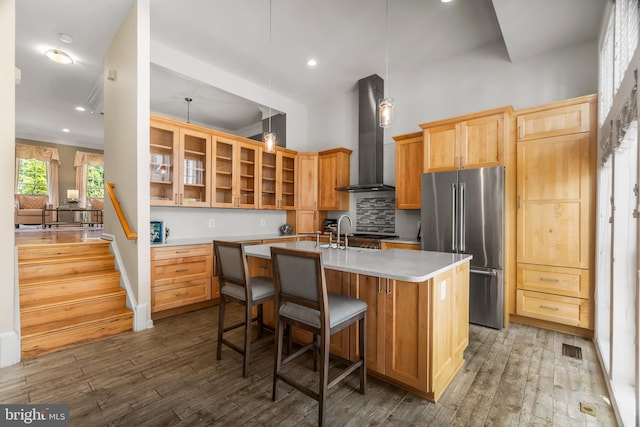 6249 Auburn Leaf Ln, Alexandria, VA 22312 - kitchen featuring high end fridge, wall chimney exhaust hood, open shelves, dark wood-type flooring, and a center island with sink