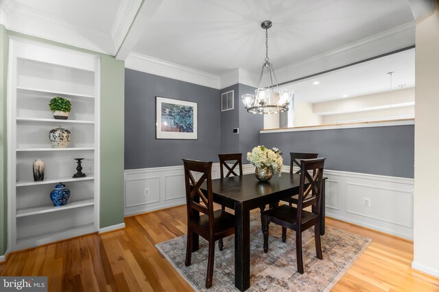 6249 Auburn Leaf Ln, Alexandria, VA 22312 - dining space with wood finished floors, a chandelier, crown molding, a wainscoted wall, and built in features