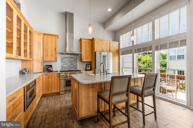 6249 Auburn Leaf Ln, Alexandria, VA 22312 - kitchen featuring premium appliances, wall chimney exhaust hood, a high ceiling, dark wood-type flooring, and decorative backsplash
