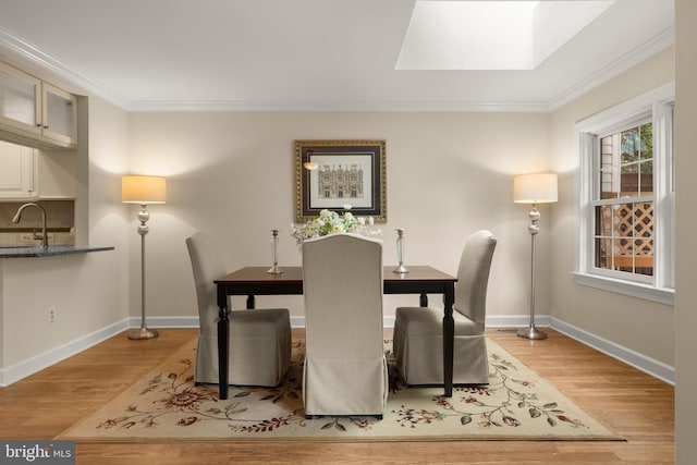 6358 Brampton Ct, Alexandria, VA 22304 - dining space with light wood-style floors, ornamental molding, baseboards, and a skylight