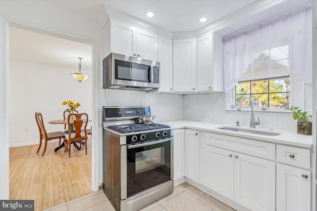 6009 Shady Spring Ave, Rosedale, MD 21237 - kitchen featuring gas stove, stainless steel microwave, a sink, light countertops, and white cabinetry
