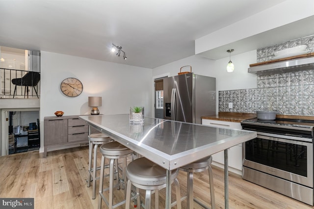 125 S Main St, Mahanoy City, PA 17948 - kitchen with appliances with stainless steel finishes, light wood-style flooring, backsplash, extractor fan, and a breakfast bar area