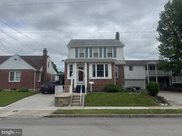 505 Boundary Ave, Hanover, PA 17331 - view of front facade featuring brick siding, a front yard, concrete driveway, and a chimney