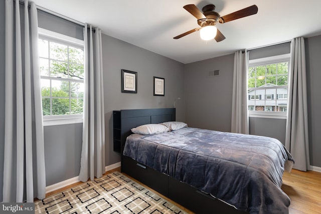 207 Wilshire Ln, Newark, DE 19711 - bedroom featuring multiple windows, baseboards, and light wood-style flooring