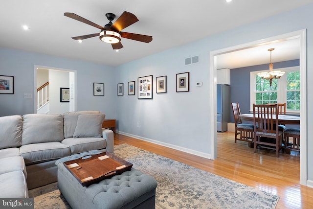 207 Wilshire Ln, Newark, DE 19711 - living room with a chandelier, light wood-type flooring, ceiling fan, baseboards, and stairs