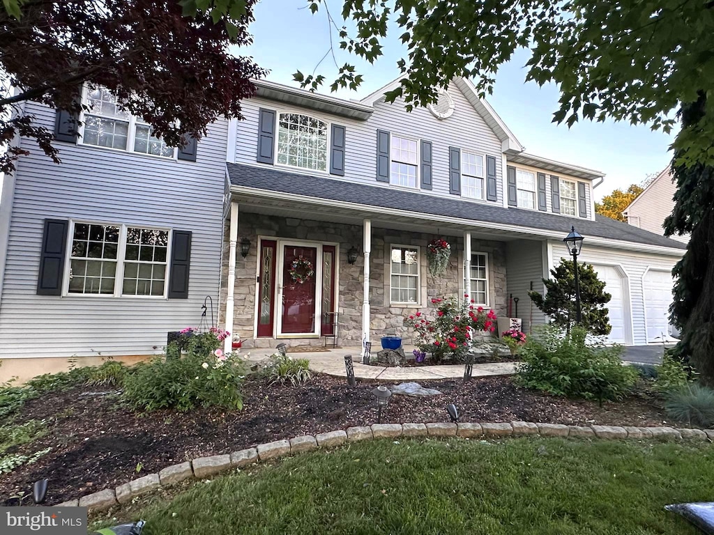 29 Colorado, Sinking Spring, PA 19608 - view of front of home featuring an attached garage, covered porch, and stone siding