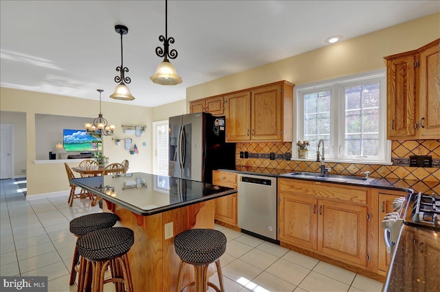 29 Colorado Ave, Sinking Spring, PA 19608 - kitchen featuring stainless steel appliances, a sink, a breakfast bar area, light tile patterned floors, and dark countertops