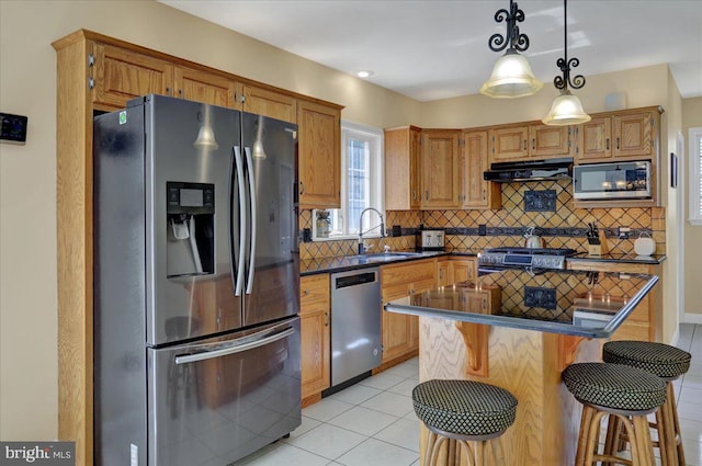 29 Colorado Ave, Sinking Spring, PA 19608 - kitchen with appliances with stainless steel finishes, a sink, under cabinet range hood, dark countertops, and light tile patterned floors