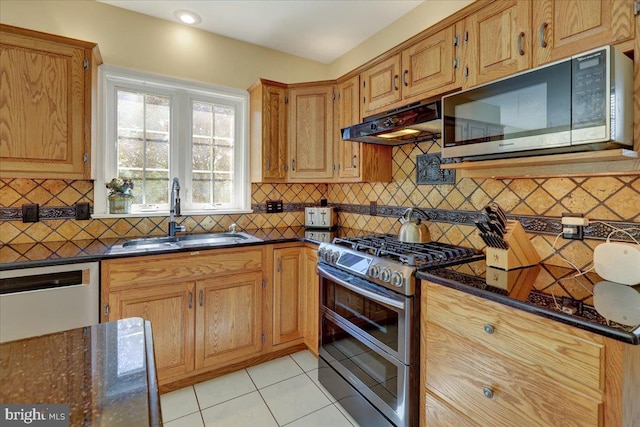 29 Colorado Ave, Sinking Spring, PA 19608 - kitchen featuring appliances with stainless steel finishes, a sink, under cabinet range hood, light tile patterned floors, and tasteful backsplash