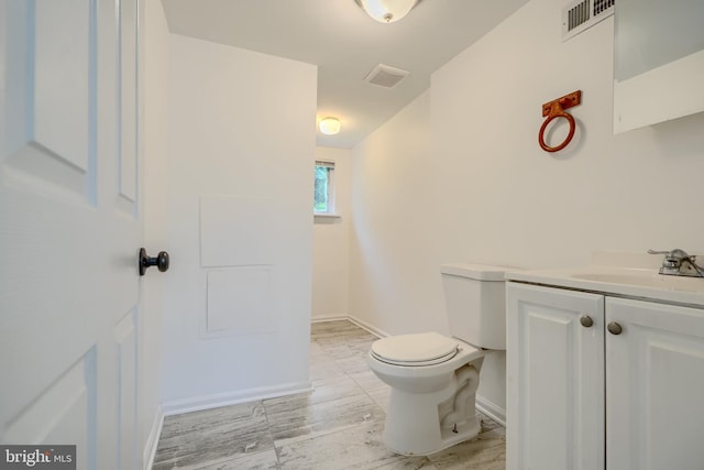 227 Elizabeth Ave, Baltimore, MD 21225 - bathroom with toilet, vanity, and baseboards