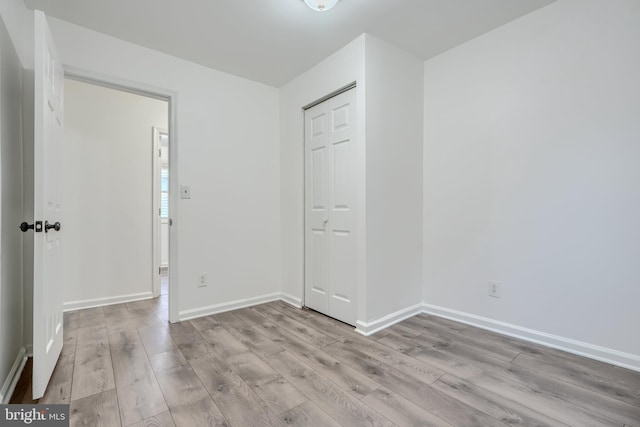 227 Elizabeth Ave, Baltimore, MD 21225 - unfurnished bedroom featuring wood finished floors, baseboards, and a closet