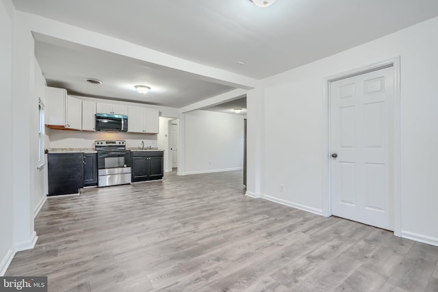 227 Elizabeth Ave, Baltimore, MD 21225 - kitchen featuring stainless steel range with electric cooktop, light wood-type flooring, baseboards, light countertops, and open floor plan