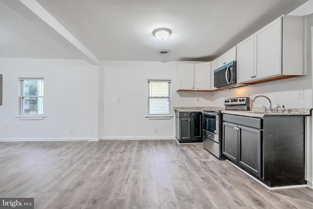 227 Elizabeth Ave, Baltimore, MD 21225 - kitchen featuring appliances with stainless steel finishes, light countertops, healthy amount of natural light, and light wood-style floors