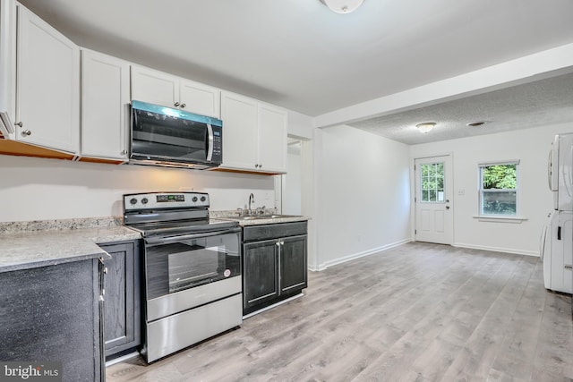 227 Elizabeth Ave, Baltimore, MD 21225 - kitchen featuring stainless steel electric range, a sink, light countertops, light wood finished floors, and white cabinetry
