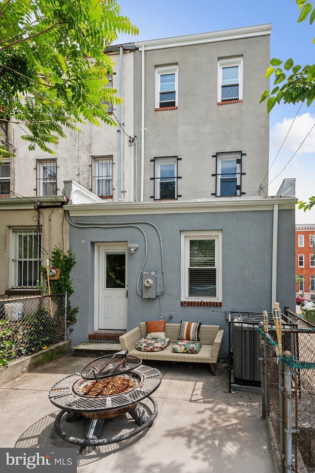 202 E Lafayette Ave, Baltimore, MD 21202 - rear view of property with stucco siding, an outdoor living space with a fire pit, and a patio