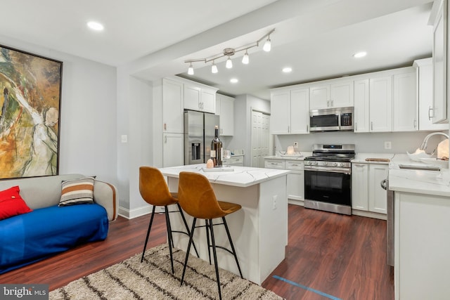 202 E Lafayette Ave, Baltimore, MD 21202 - kitchen with appliances with stainless steel finishes, a sink, dark wood-type flooring, white cabinetry, and light stone countertops