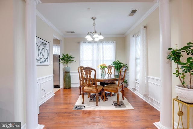 9722 Holmes Pl Unit 307, Manassas Park, VA 20111 - dining area with a chandelier, ornate columns, a decorative wall, wood finished floors, and ornamental molding