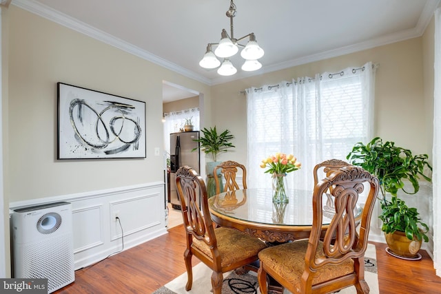9722 Holmes Pl Unit 307, Manassas Park, VA 20111 - dining space featuring healthy amount of natural light, a chandelier, wood finished floors, and ornamental molding