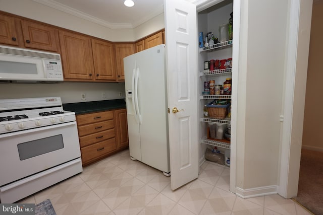 508 Limerick Cir Unit 402, Lutherville Timonium, MD 21093 - kitchen featuring white appliances, brown cabinetry, crown molding, dark countertops, and baseboards