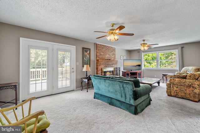 23359 Patuxent View Rd, Lexington Park, MD 20653 - carpeted living area with a textured ceiling, a brick fireplace, ceiling fan, and baseboards