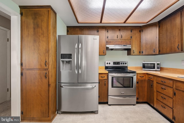 23359 Patuxent View Rd, Lexington Park, MD 20653 - kitchen featuring stainless steel appliances, under cabinet range hood, light countertops, and brown cabinetry