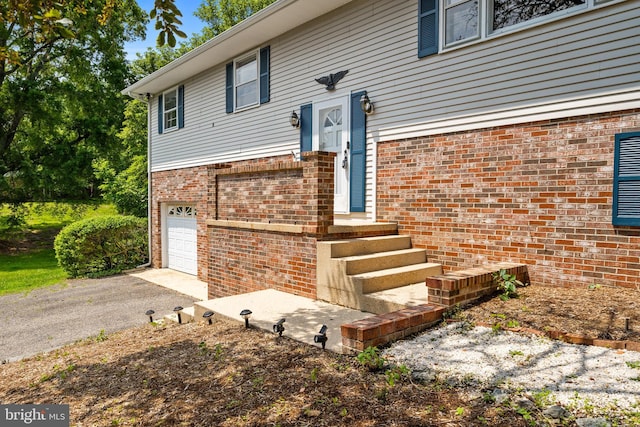 23359 Patuxent View Rd, Lexington Park, MD 20653 - property entrance featuring a garage, brick siding, and asphalt driveway
