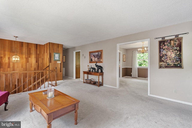 23359 Patuxent View Rd, Lexington Park, MD 20653 - living room featuring a chandelier, light colored carpet, baseboards, a textured ceiling, and wooden walls