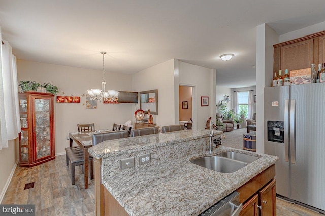 109 Riverwalk Blvd, Burlington, NJ 08016 - kitchen with appliances with stainless steel finishes, a sink, light wood finished floors, a kitchen island with sink, and open floor plan