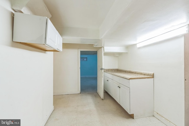 224 University Blvd E, Silver Spring, MD 20901 - kitchen with white cabinetry, light floors, baseboards, and light countertops