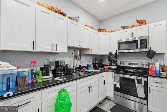 3125 N 7th St, Philadelphia, PA 19133 - kitchen featuring stainless steel appliances, a sink, white cabinets, and dark stone countertops