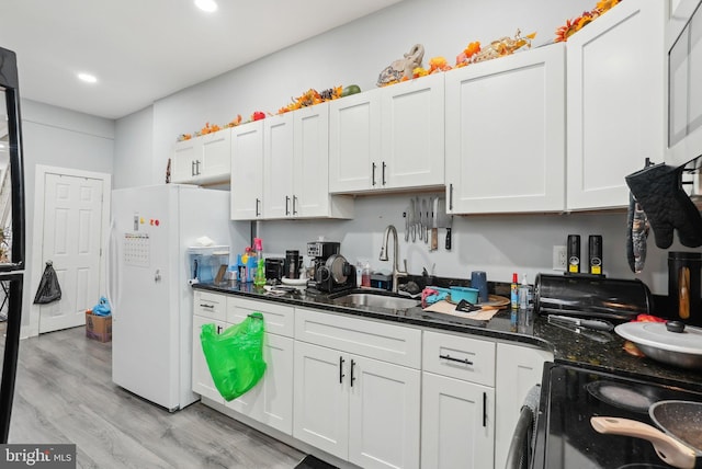 3125 N 7th St, Philadelphia, PA 19133 - kitchen featuring freestanding refrigerator, black electric range oven, a sink, light wood-style flooring, and white cabinets