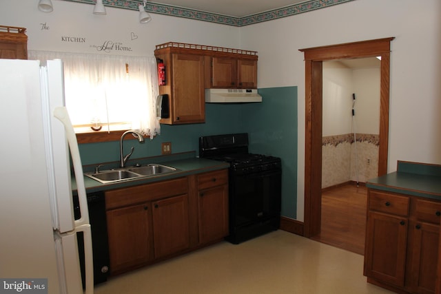 5077 Lincoln Hwy W, Thomasville, PA 17364 - kitchen featuring black appliances, under cabinet range hood, a sink, brown cabinetry, and dark countertops