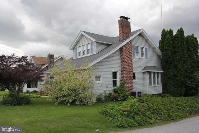 5077 Lincoln Hwy W, Thomasville, PA 17364 - view of home's exterior with a chimney, roof with shingles, a lawn, and cooling unit