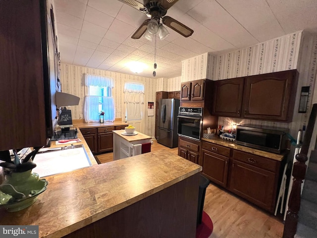 460 Baltimore St, Gettysburg, PA 17325 - kitchen featuring oven, wallpapered walls, freestanding refrigerator, stainless steel microwave, and dark brown cabinets