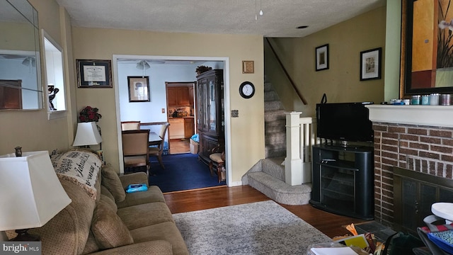 410 Beechwood Ave, Trenton, NJ 08618 - living room featuring wood finished floors, stairway, a brick fireplace, and a textured ceiling