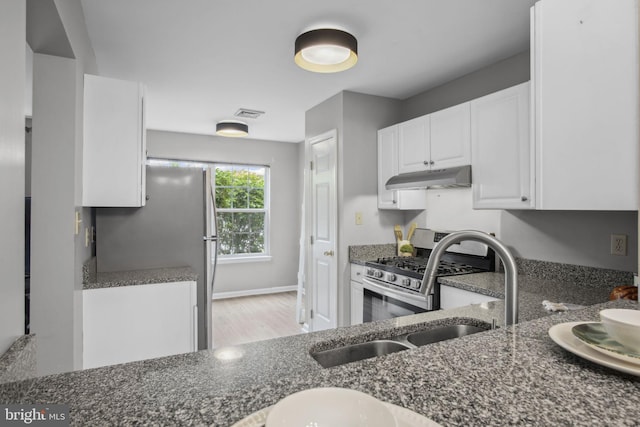 204 Fawn Rdg N, Harrisburg, PA 17110 - kitchen with under cabinet range hood, stainless steel appliances, dark stone countertops, white cabinets, and light wood-style flooring