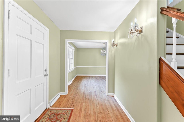 242 Pennwood St, Newark, DE 19713 - hall featuring a chandelier, light wood-style floors, baseboards, and baseboard heating