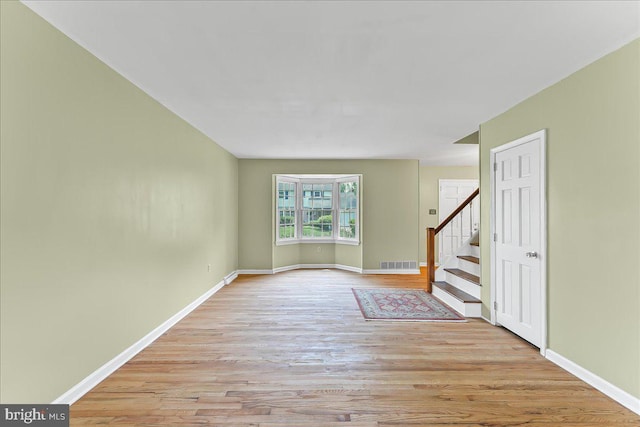 242 Pennwood St, Newark, DE 19713 - unfurnished living room featuring light wood finished floors, stairway, and baseboards