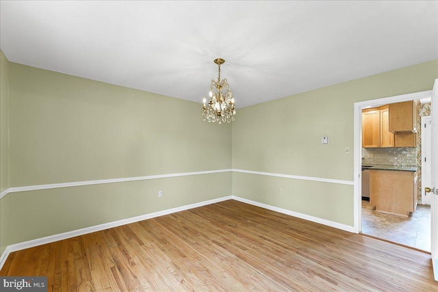 242 Pennwood St, Newark, DE 19713 - empty room with light wood-style floors, a chandelier, and baseboards