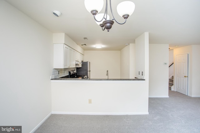 144 Carousel Cir, Doylestown, PA 18901 - kitchen with dark countertops, light carpet, backsplash, stainless steel appliances, and a chandelier