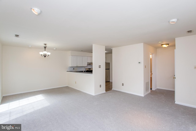 144 Carousel Cir, Doylestown, PA 18901 - unfurnished living room featuring light carpet, a chandelier, and baseboards