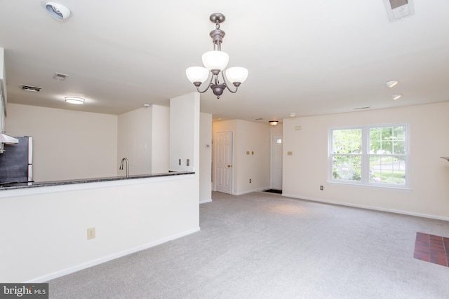 144 Carousel Cir, Doylestown, PA 18901 - unfurnished living room featuring carpet flooring, a chandelier, baseboards, and a sink